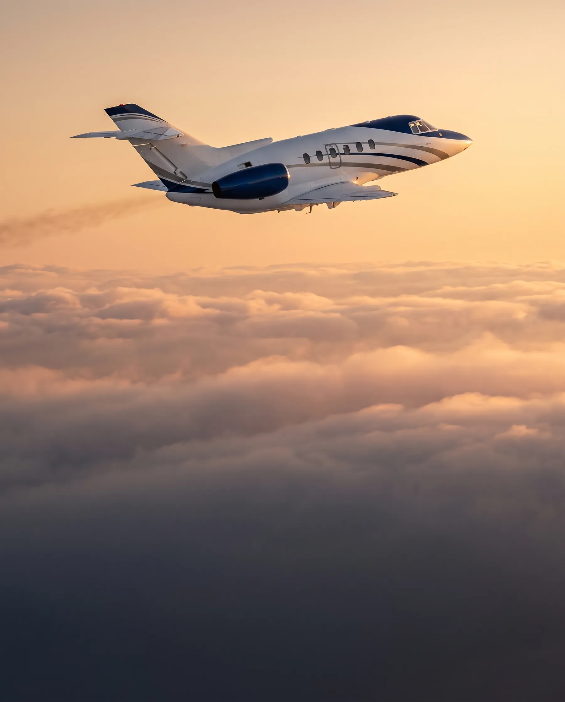 Jet privado en vuelo en el tercio superior de un cielo cálido